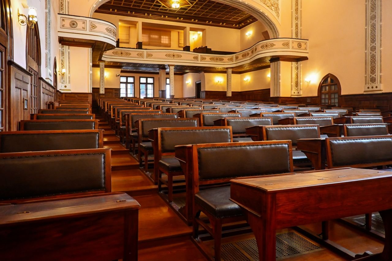 A historic lecture hall featuring wooden benches and classic architectural details, ideal for educational settings.